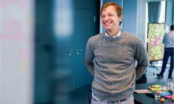 Seminar-Teilnehmender steht von Flip-Chart und lacht